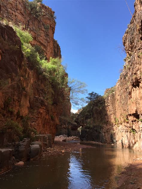 a river flowing through a rocky canyon under a blue sky