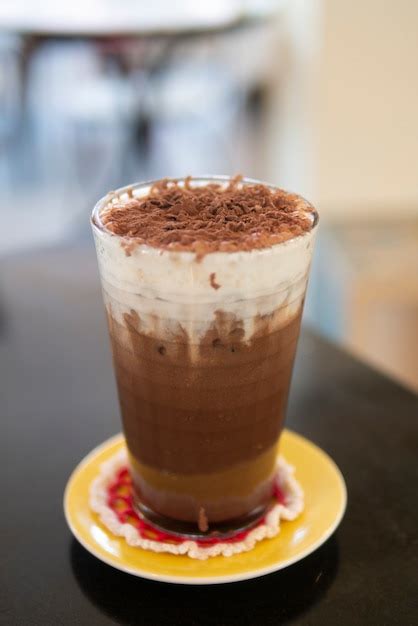 Premium Photo | Iced cocoa chocolate drink with cream foam topped with cocao powder cold drink ...