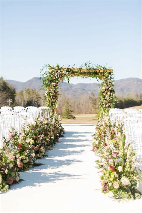 Outdoor Mountain Ceremony with Natural, Rustic Wedding Arch and Whimsical Floral Aisle Decorations