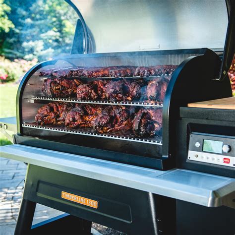 a bbq grill with meat cooking on it's side and the lid open