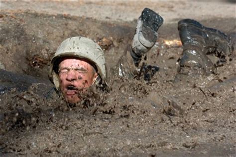 An Air Force Academy cadet trainee attacks the mud pit.