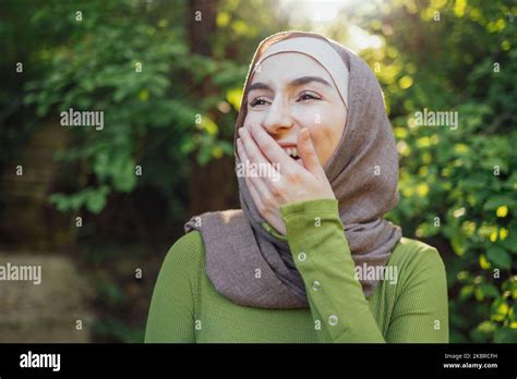 Beautiful joyful teen high school girl wearing colorful muslim clothing having fun outdoors ...