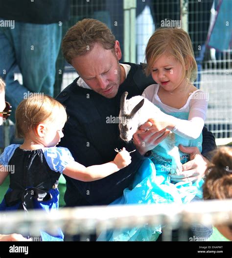 Ian Ziering and his daughters, Penna and Mia, play with a rabbit at the Studio City Farmers ...