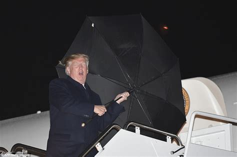 President Trump grapples with his umbrella after rally | Daily Mail Online