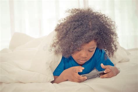 Little Kid is Playing with Smartphone on Bed Stock Image - Image of smartphone, person: 114604139