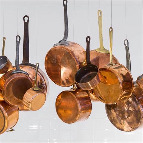 copper pots and pans hanging from hooks