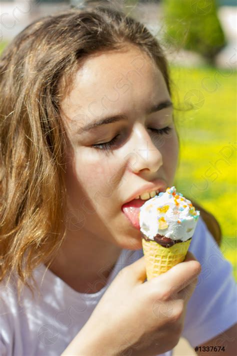 Beautiful teen girl eating ice cream in a waffle cone - stock photo 1337674 | Crushpixel