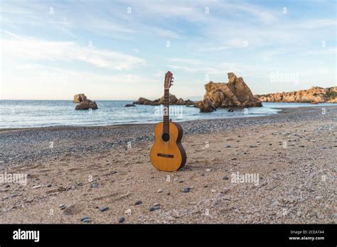 Classic acoustic guitar placed at the ocean on a beach Stock Photo - Alamy