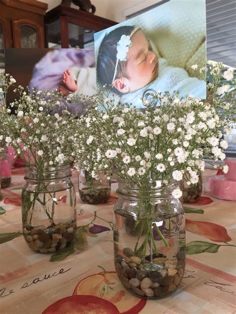 Centerpieces for baby girl's baptism reception: mason jar, rocks, photo holder, baby's breath ...