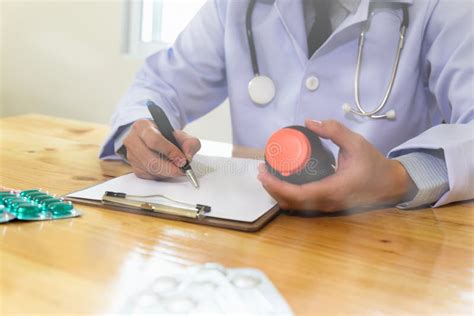 Doctor Writing RX Prescription in Medical Office Clinic with Drugs on Desk Stock Photo - Image ...