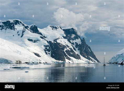 A sailing boat and snow-covered mountains, Lemaire Channel, near Graham Land Antarctica Stock ...