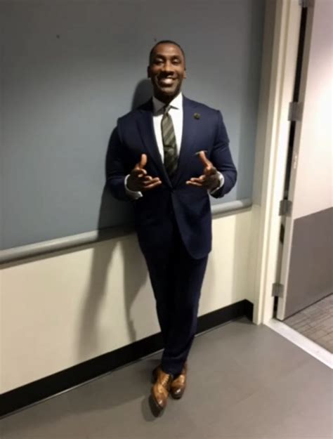 a man in a suit standing next to a wall