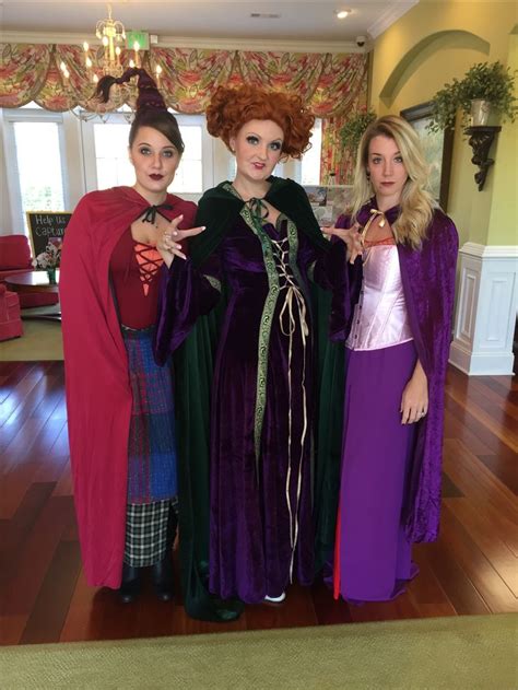 three women dressed in costumes posing for the camera with one woman ...