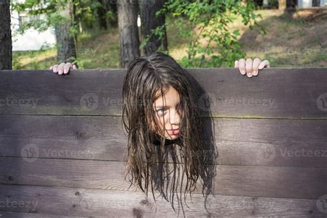 the head of a girl with long disheveled hair clamped in a guillotine, a scene of a medieval ...