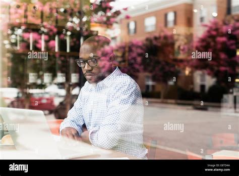 Black man using laptop in coffee shop Stock Photo - Alamy