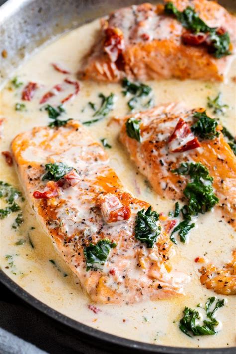 Tender salmon filets smothered in a rich garlic cream sauce filled with sun-dried tomatoes, kale ...