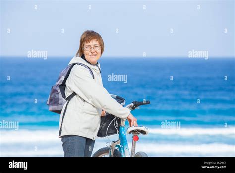 A nice senior lady riding a bike on the beach Stock Photo - Alamy