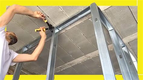 a man working on a metal ladder in a room with yellow walls and flooring