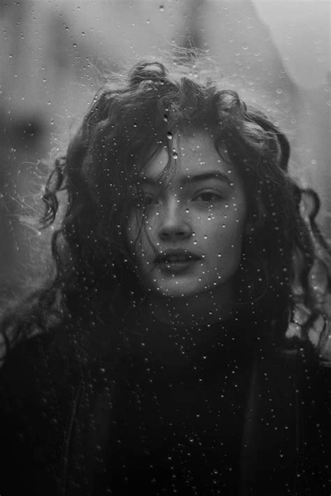 a woman standing in the rain with her eyes closed