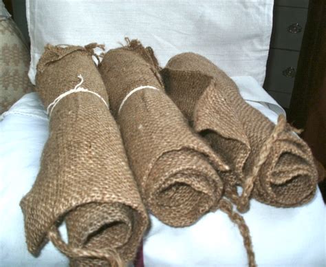 three rolled up burlocks sitting on top of a bed