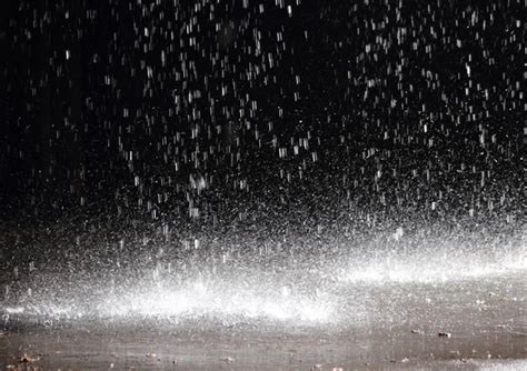 Massive rainfall on asphalt from a broken gutter under a cloudbu ...