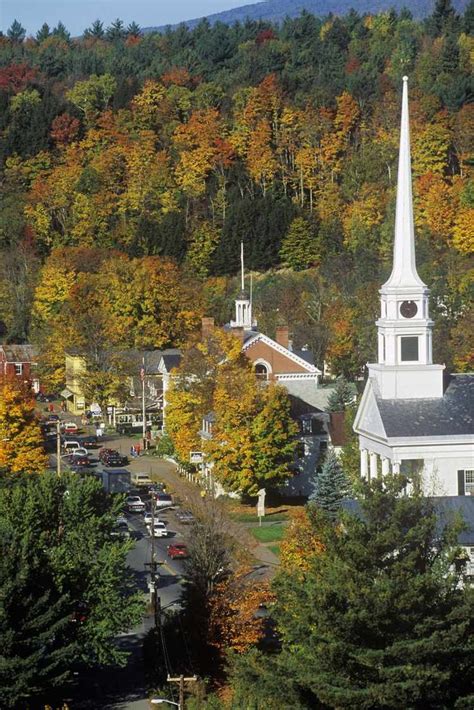 an aerial view of a small town surrounded by trees with fall foliage in ...