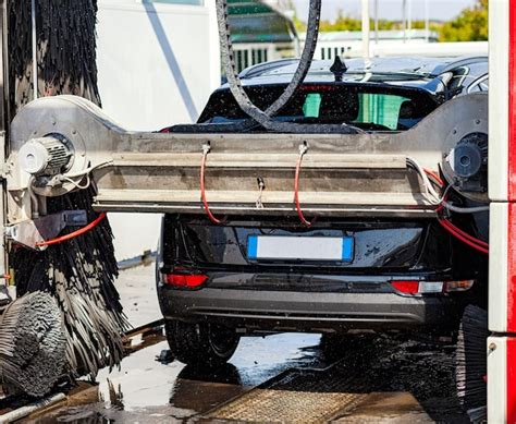 Premium Photo | Black car in automatic car wash rotating red and black ...