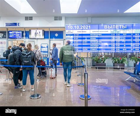 Passengers in front of Departures information display with flights in ...