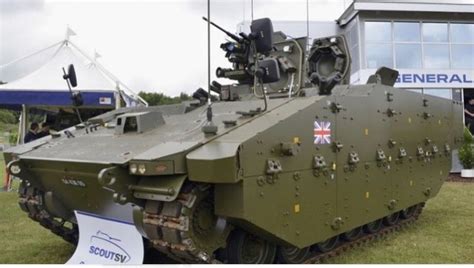 an army tank is on display in front of a building with people looking at it