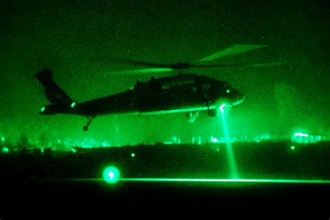 As seen through a night-vision device, a UH-60L Black Hawk helicopter ...