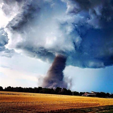 a large cloud is in the sky over a field