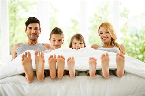 Family In Bed Showing Feet Under Duvet Stock Photo - Download Image Now ...