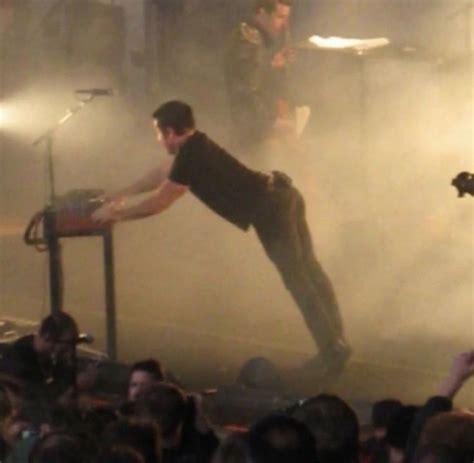 a man standing on top of a stage next to a crowd