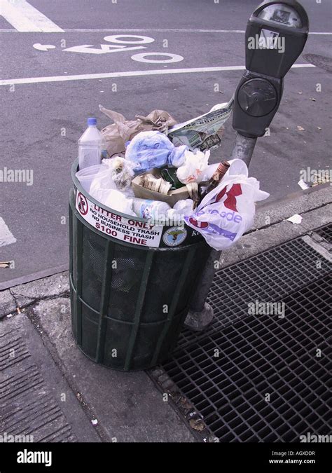 Trash can full, overflowing on the sidewalk in New York City color photograph Stock Photo - Alamy