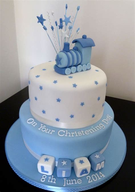 a blue and white birthday cake with a train on it's top, sitting on a table