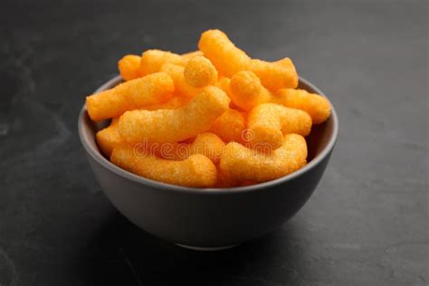 Many Tasty Cheesy Corn Puffs in Bowl on Black Table, Closeup View Stock Photo - Image of puff ...