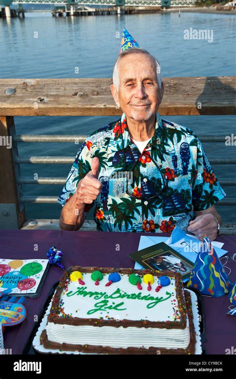 83 year old man pauses for thumbs up with his birthday cake while Stock Photo: 51222995 - Alamy