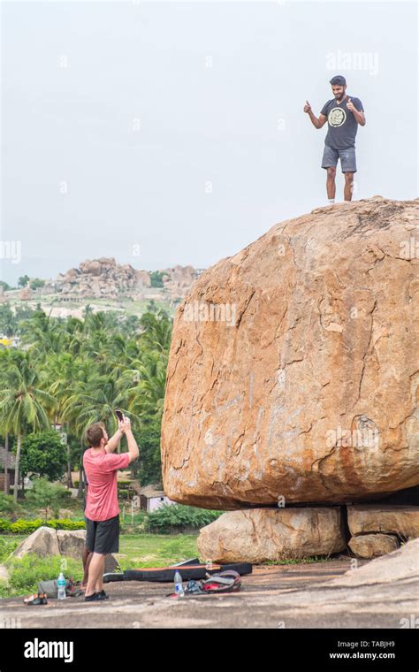 Tourists rock climbing in Hampi, India Stock Photo - Alamy