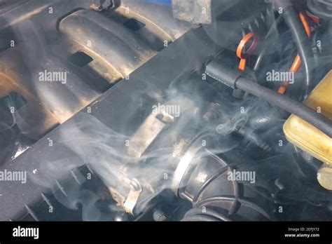 Smoke under the hood of a car. Car engine smokes Stock Photo - Alamy