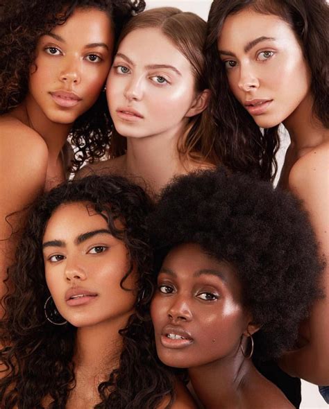 four beautiful women posing for the camera in front of a white ...