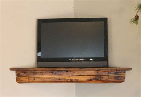 a flat screen tv sitting on top of a wooden shelf