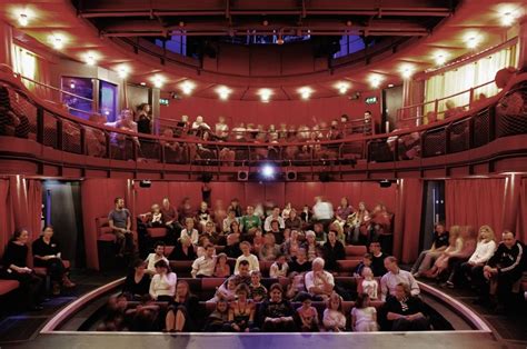 a group of people sitting in front of a red stage