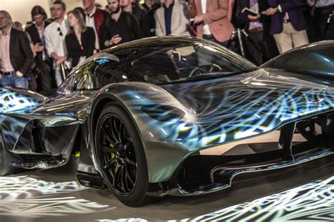 a futuristic car is on display in front of a group of people at an event