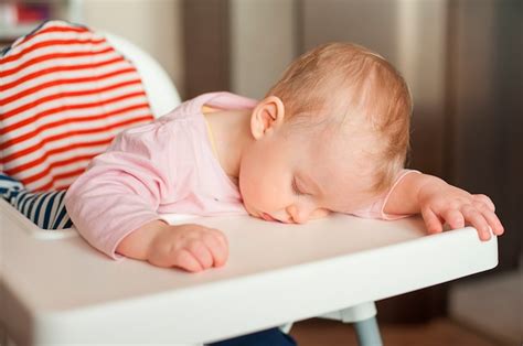 Premium Photo | Tired child sleeping in highchair after the lunch. cute baby girl over eating ...