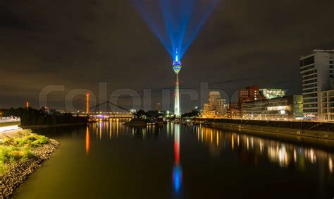 Dusseldorf skyline at night with light beaming from the rheinturm ...