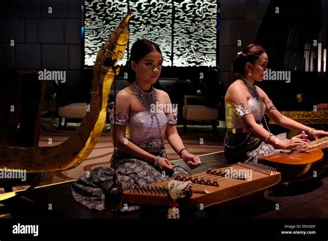 Young Thai women playing the Khim a wooden hammered dulcimer traditional music instrument from ...