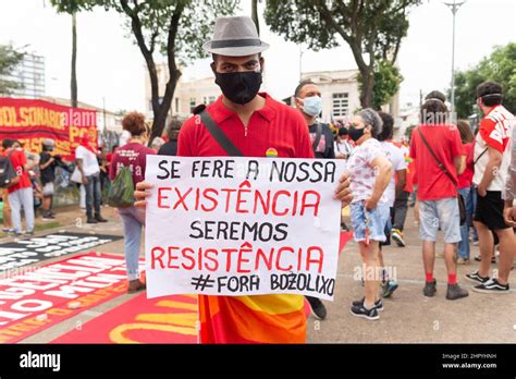 Brazilian in a mask with a poster protests against President Jair ...