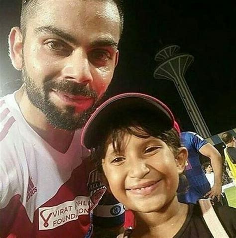 a man with a beard standing next to a little boy wearing a baseball cap ...