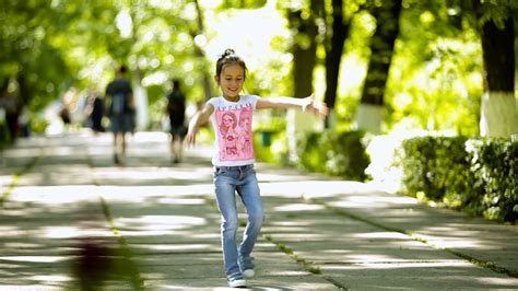 Little brunette girl doing somersault, upheaval, gymnastics in the park. Stock Video Footage 00: ...