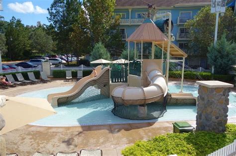 an outdoor pool with a slide and umbrellas